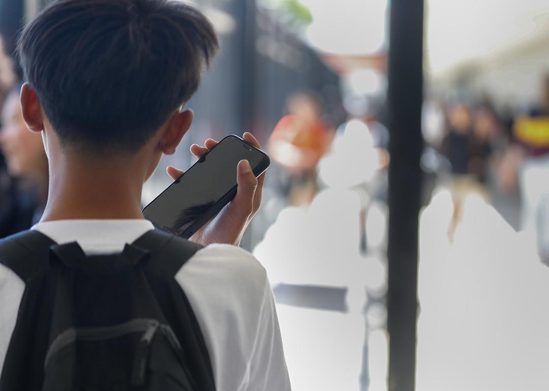 A young student uses mobile phone after unlocking it from secured usage during the school day.