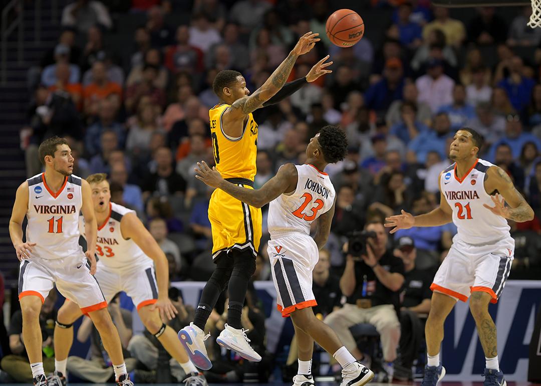 UMBC guard Jairus Lyles (10) and four UVA defenders during the 2018 Men's NCAA basketball tournament at the Spectrum Center in Charlotte, North Carolina.