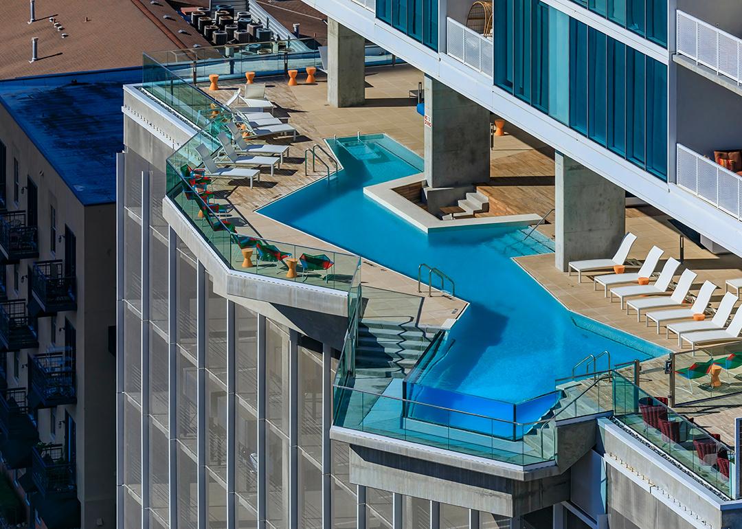 A view of a bright blue modern luxury pool on an outdoor terrace in a residential skyscraper building in downtown Austin, Texas.