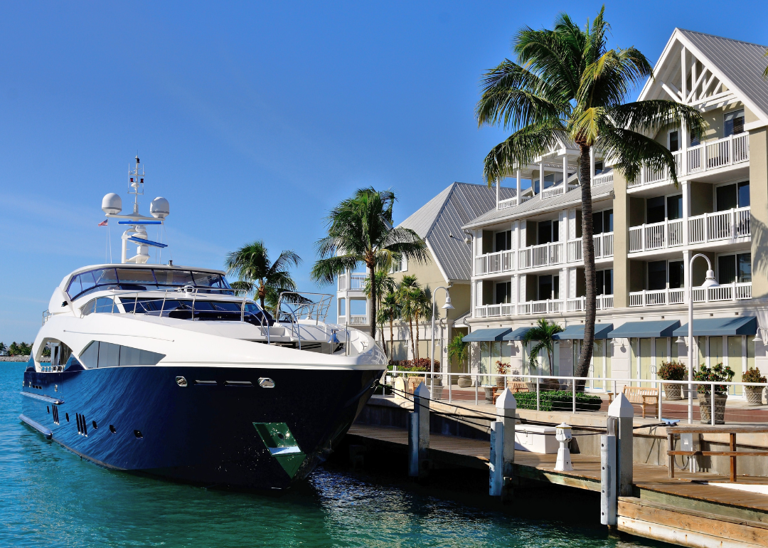 Luxury yacht docked in front of tropical waterfront condominiums