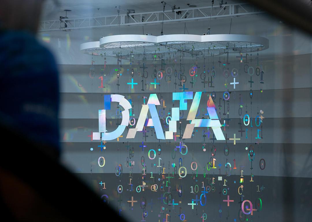 A hanging structure made up of holographic binary symbols and forming the word "DATA".