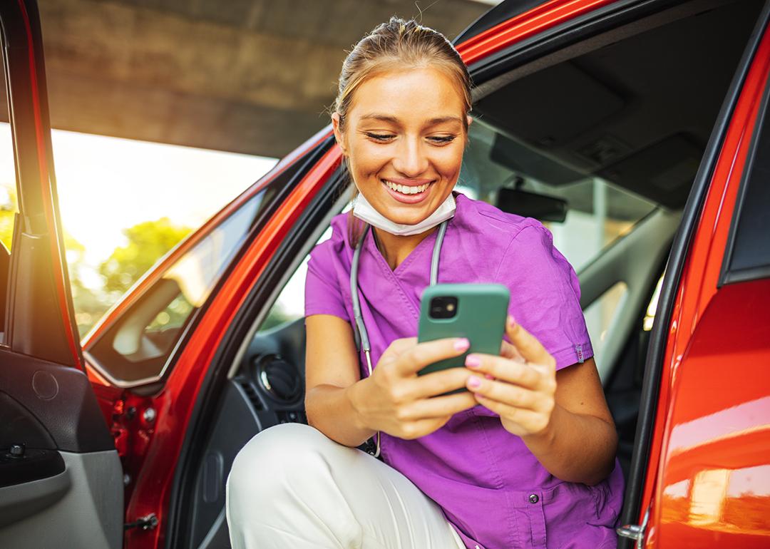 A happy travel nurse taking a break in her car.