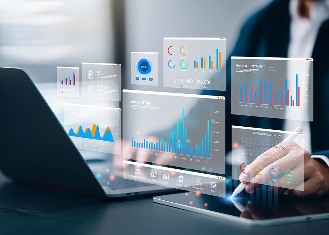 Accountant using a laptop and digital tablet with holographic visualizations of an accounting software.
