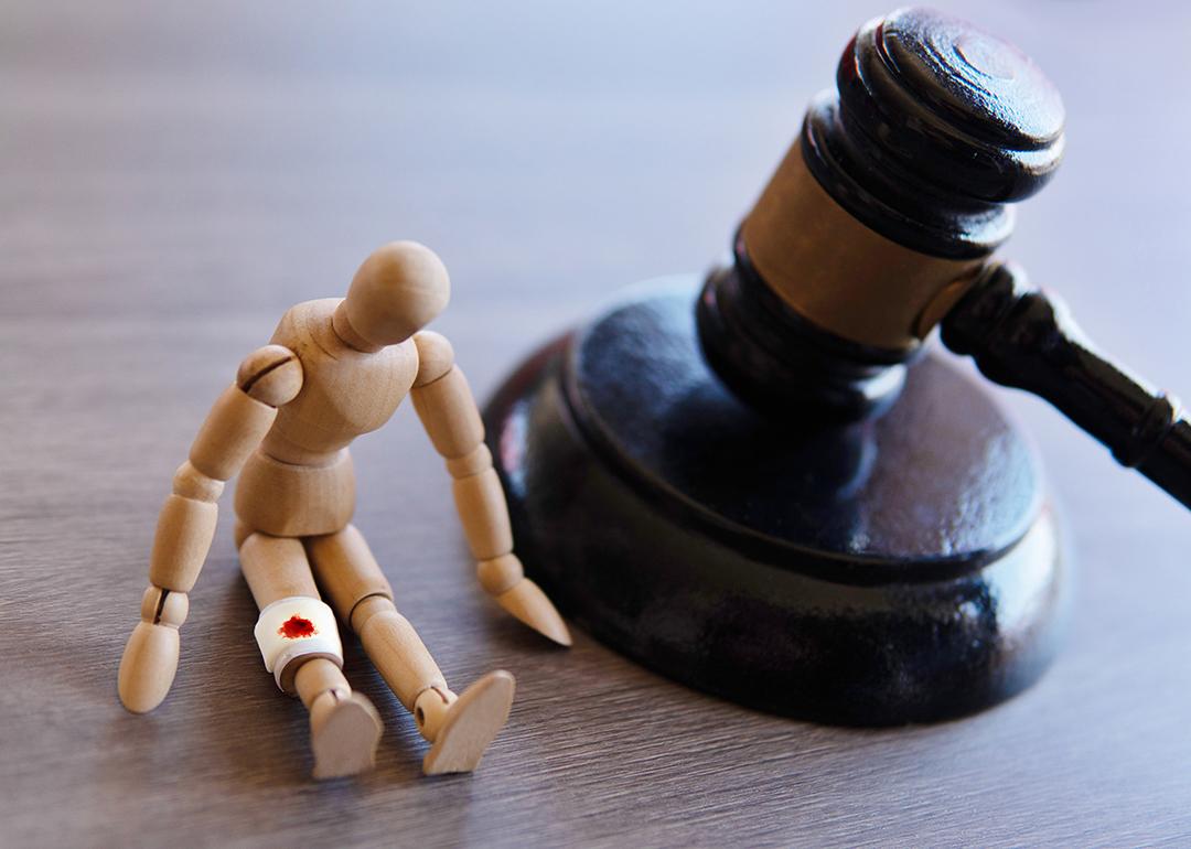 A judge gavel beside a wooden injured figure as a concept of personal injury law.