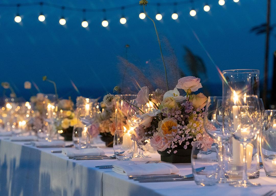 A wedding's dinner table reception outdoors during sunset.