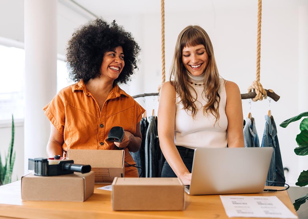 Two happy businesswomen preparing orders for e-commerce company.