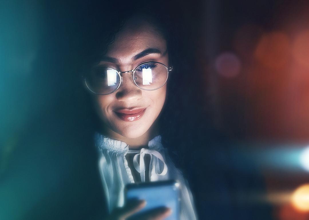 A female employee using a phone at night.