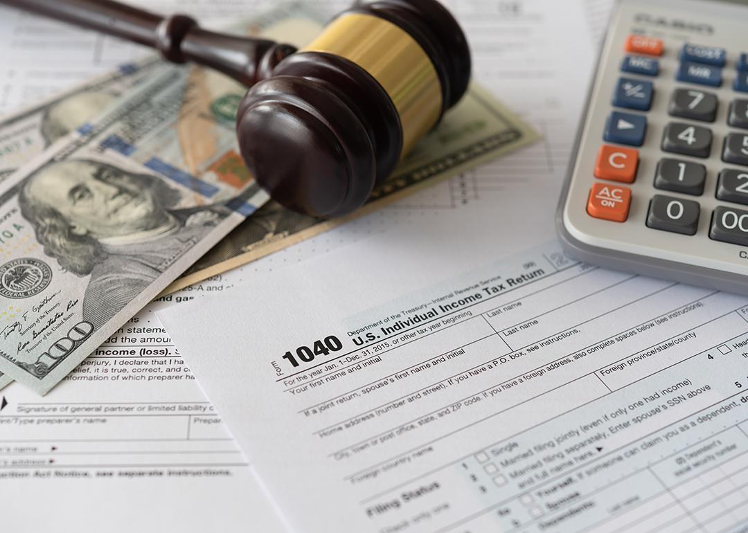 Tax law changes concept showing tax forms, bank notes, a calculator and a judge gavel.