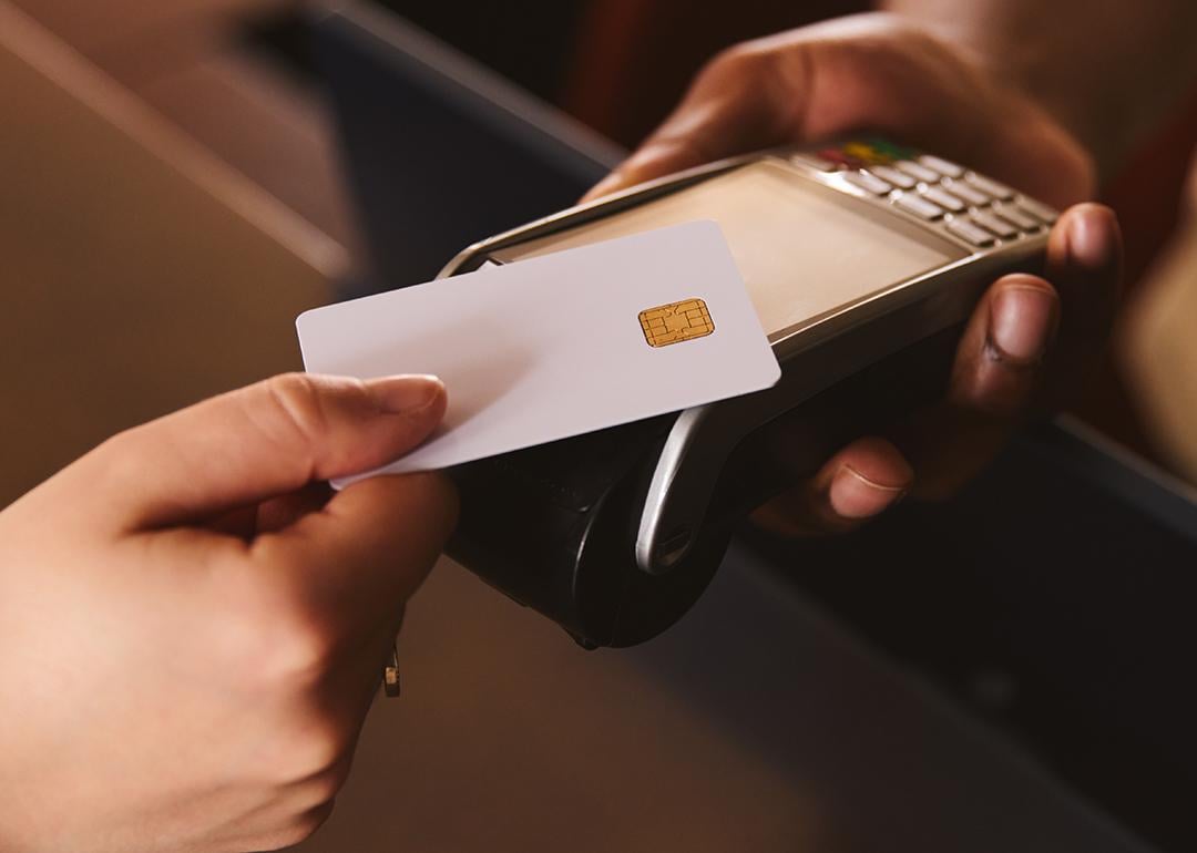 A credit card being tapped on a contactless payment terminal.