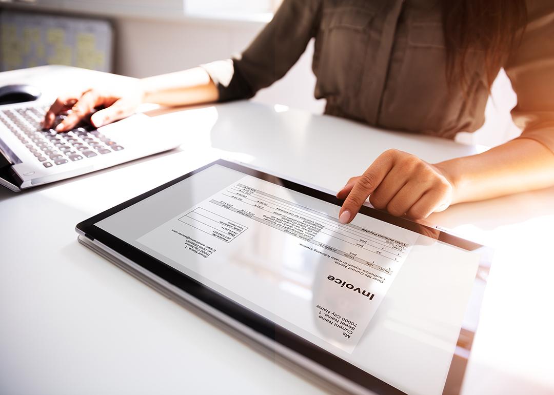 Invoice processing using a laptop and a separate digital tablet.