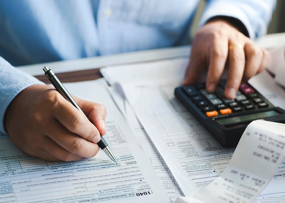 Businessperson calculating taxes and filling out a tax form.