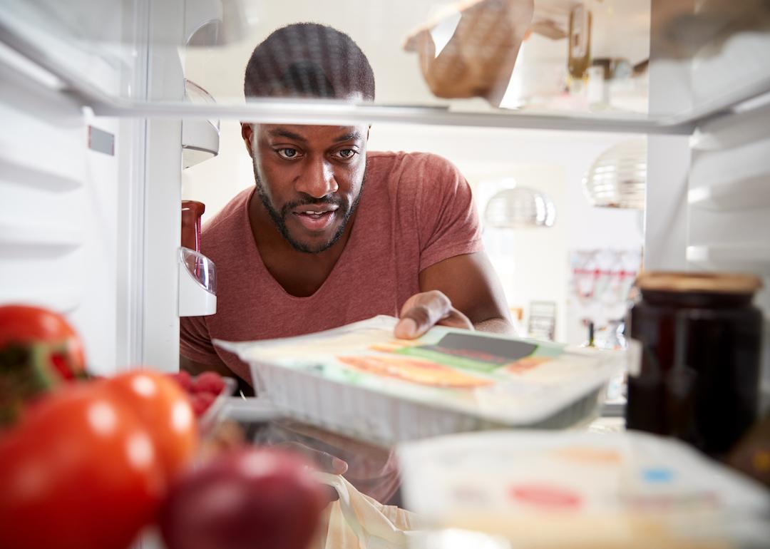 Person removing package of food from fridge.