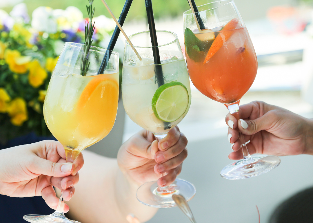 Hands clinking glasses of fruity cocktails together