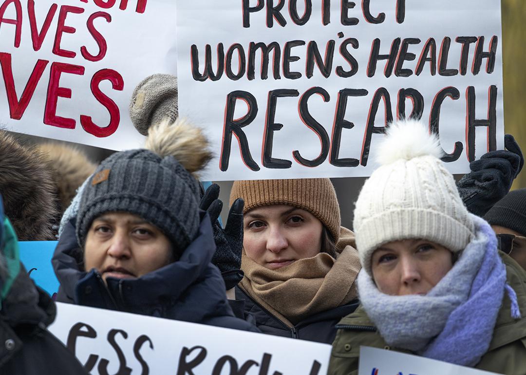 People gather on the University of Illinois Chicago (UIC) campus holding signs to protest the potential loss of federal funding for medical research.