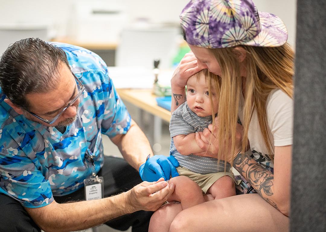 One year-old River Jacobs is held by his mother while he receives an MMR vaccine at a vaccine clinic in Lubbock, Texas. 