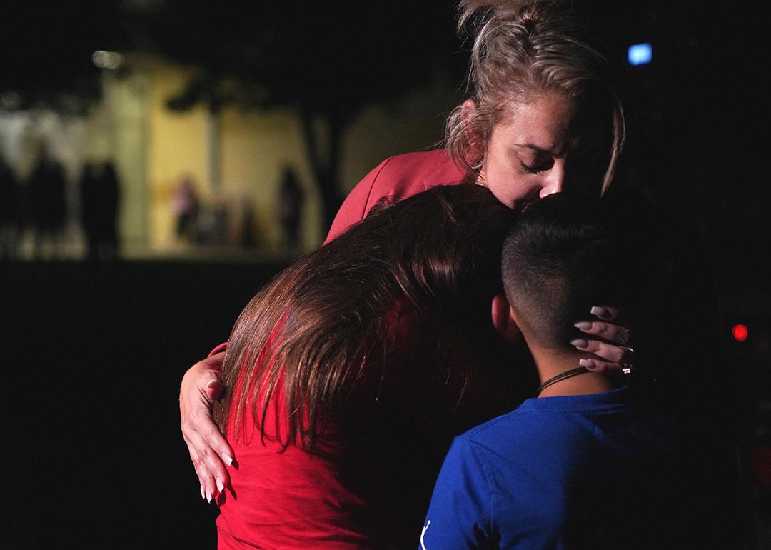 Families hug outside the Willie de Leon Civic Center where grief counseling is offered after a school shooting in Uvalde, Texas.