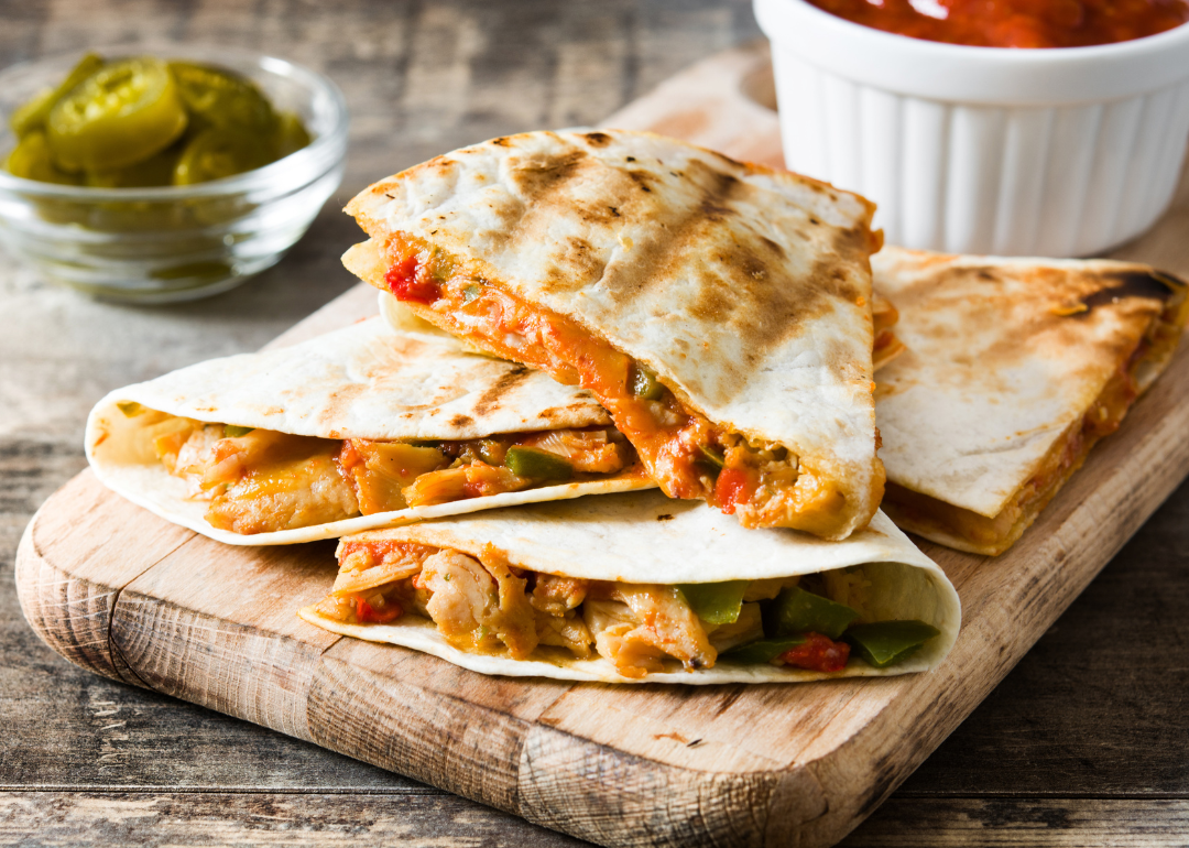 Mexican quesadilla with chicken, cheese and peppers on a wooden table.