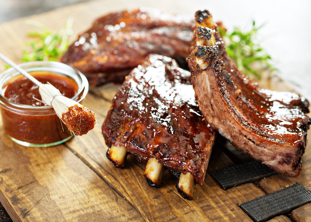 Grilled and smoked ribs with barbeque sauce on a carving board