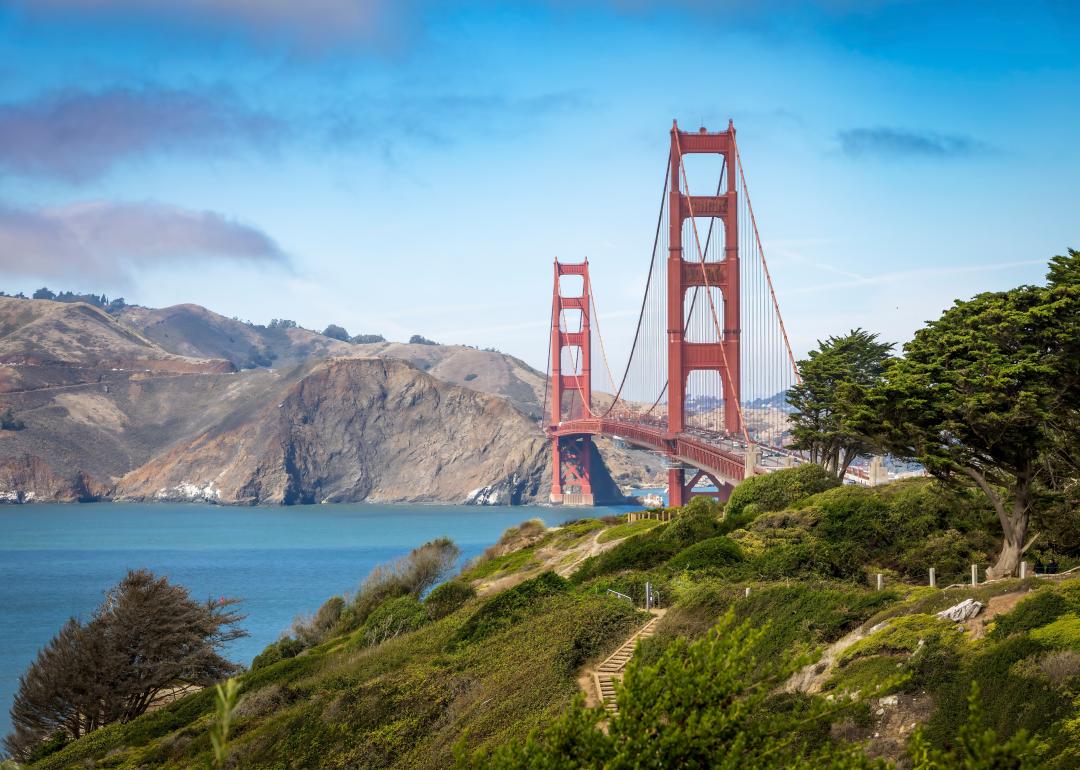 A stunning view of the Golden Gate Bridge surrounded by lush greenery and the calm waters of the San Francisco Bay.