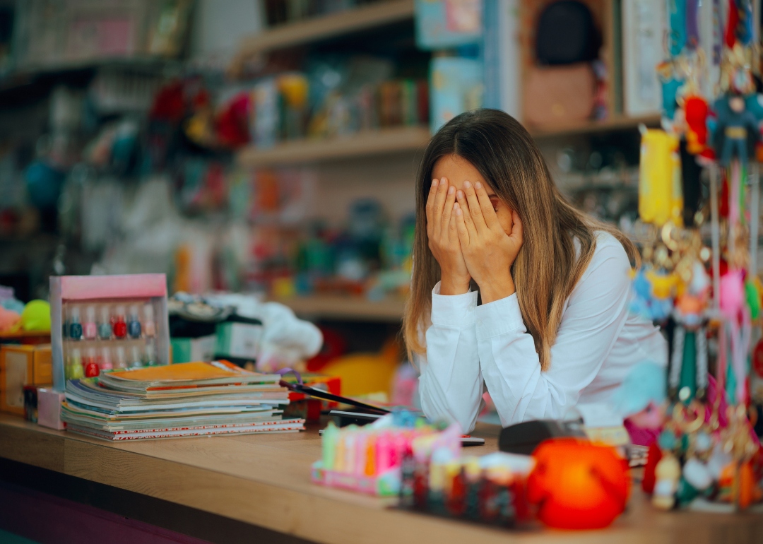 Unhappy salesperson looking exhausted behind the counter