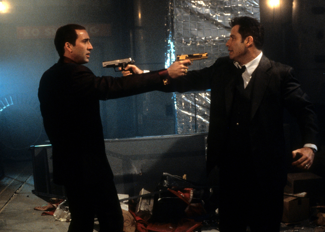 Nicolas Cage and John Travolta aiming guns at each other in a scene from the film 'Face/Off', 1997.