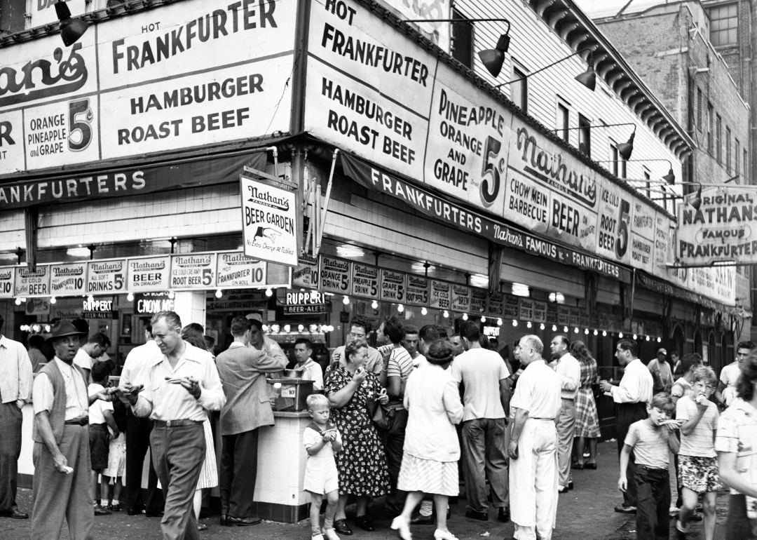A large crowd orders and eats hotdogs outside the original Nathans Famous Hot Dog stand in Coney Island, Brooklyn, New York, August 6, 1947.