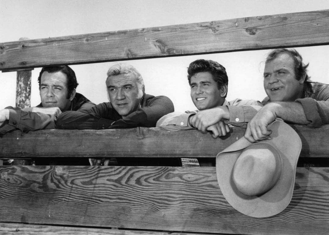 Dan Blocker holds his hat while standing with others in a scene from the TV series “Bonanza” (1959–1973).