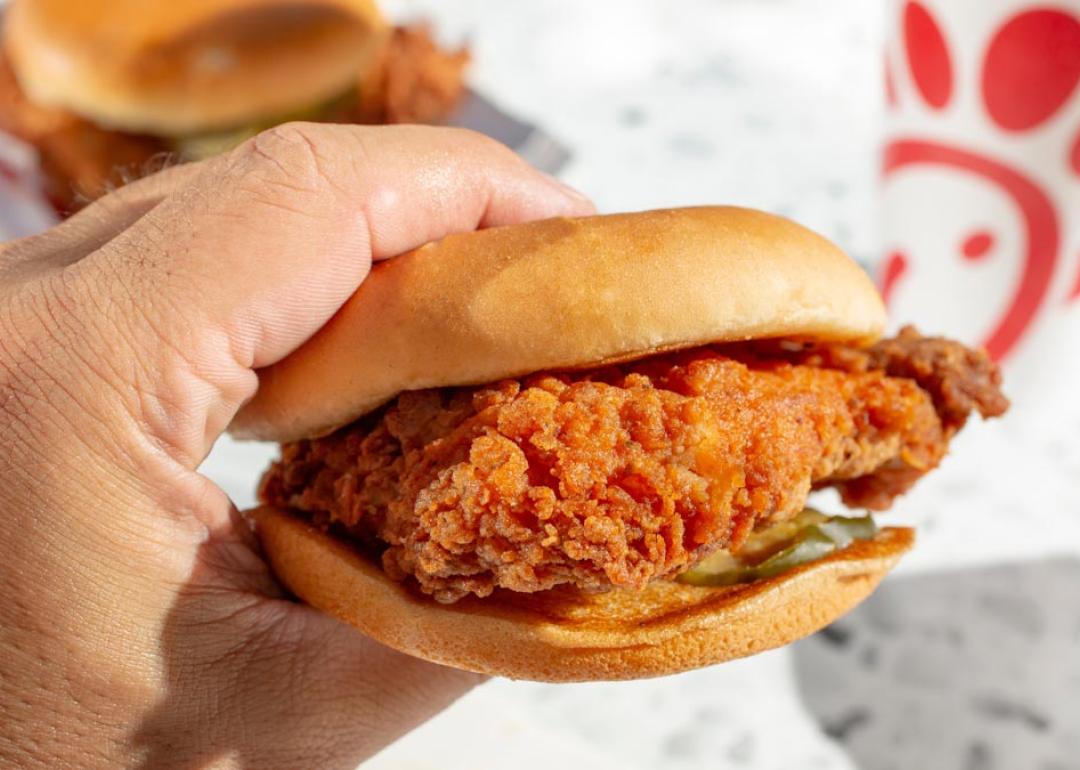 A view of a hand holding a Chick-Fil-A chicken sandwich.