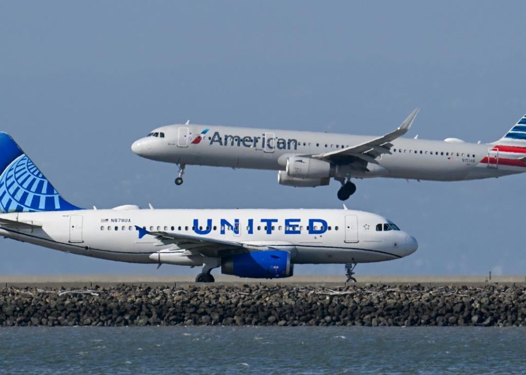 A United Airlines plane is taxiing to takeoff as an American Airlines plane lands at San Francisco International Airport