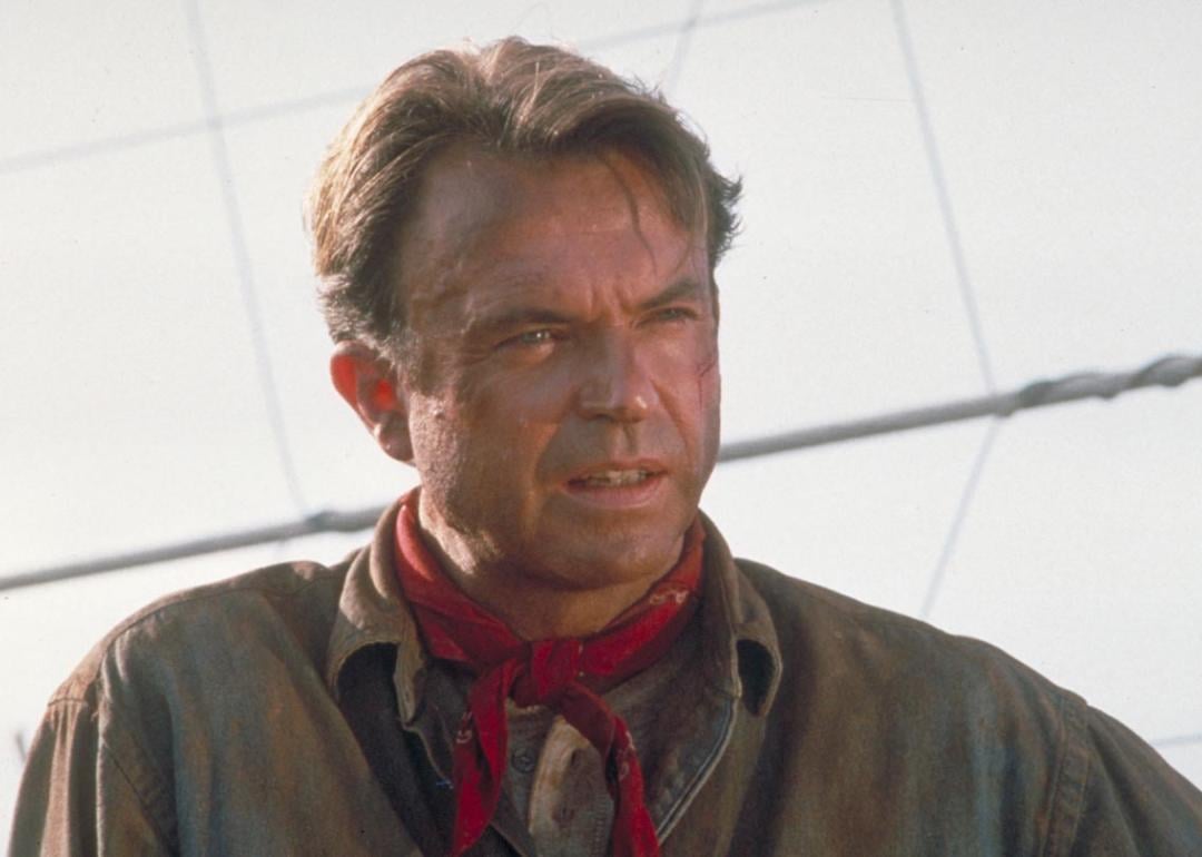 Actor Sam Neill as Dr. Alan Grant, next to an electric fence in a scene from the film 'Jurassic Park', 1993.