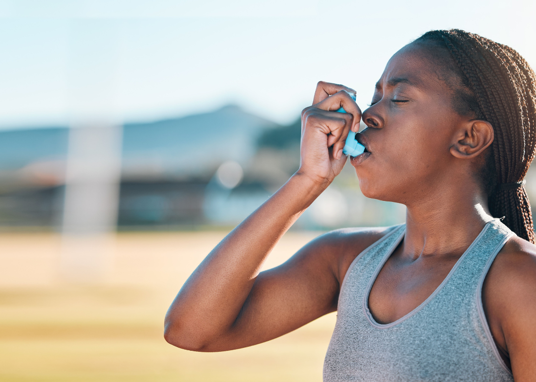 A woman using an inhaler.