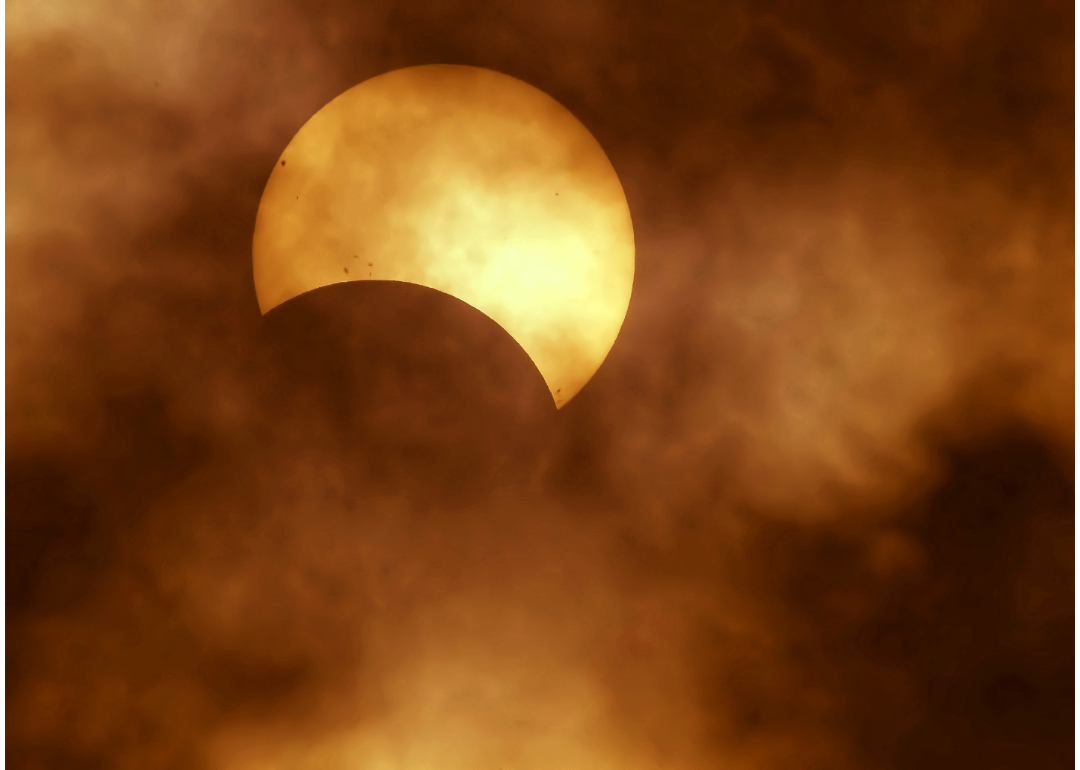 The beginning of a solar eclipse as seen through very light cloud cover.