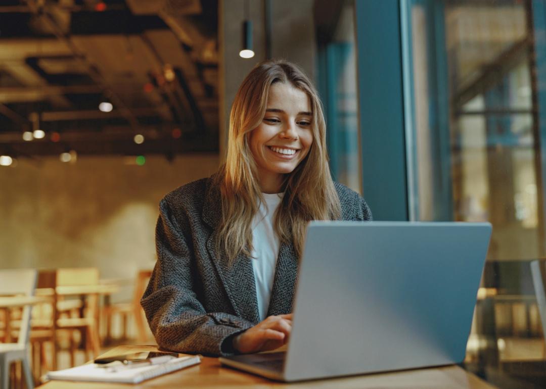 Stylish woman working on a laptop while sitting in cozy cafe.