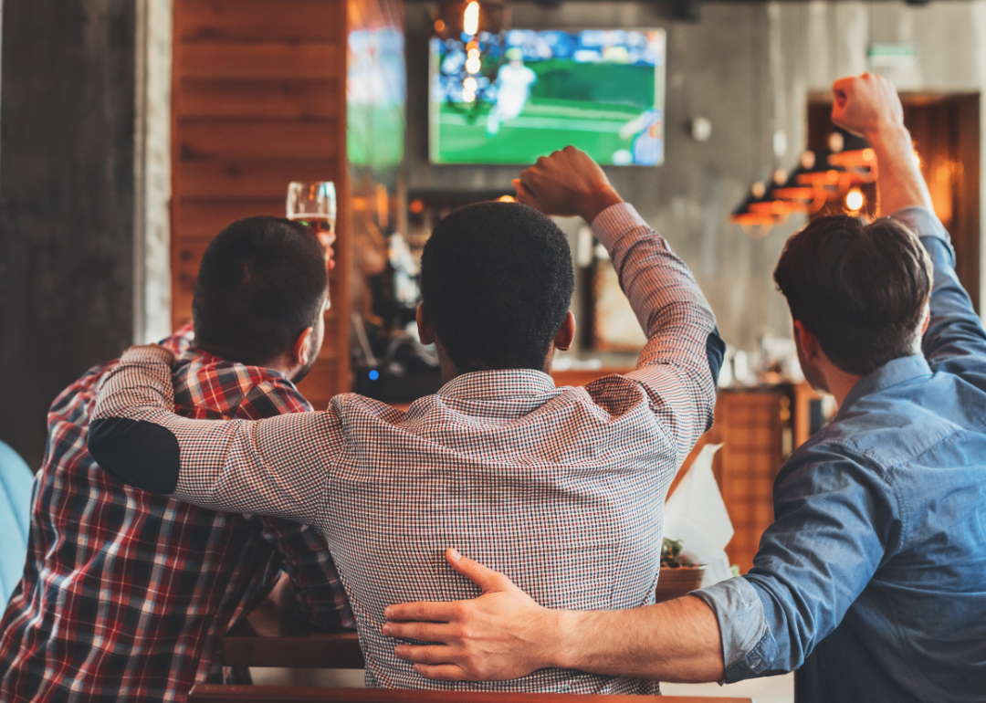 Three fans watch football on TV