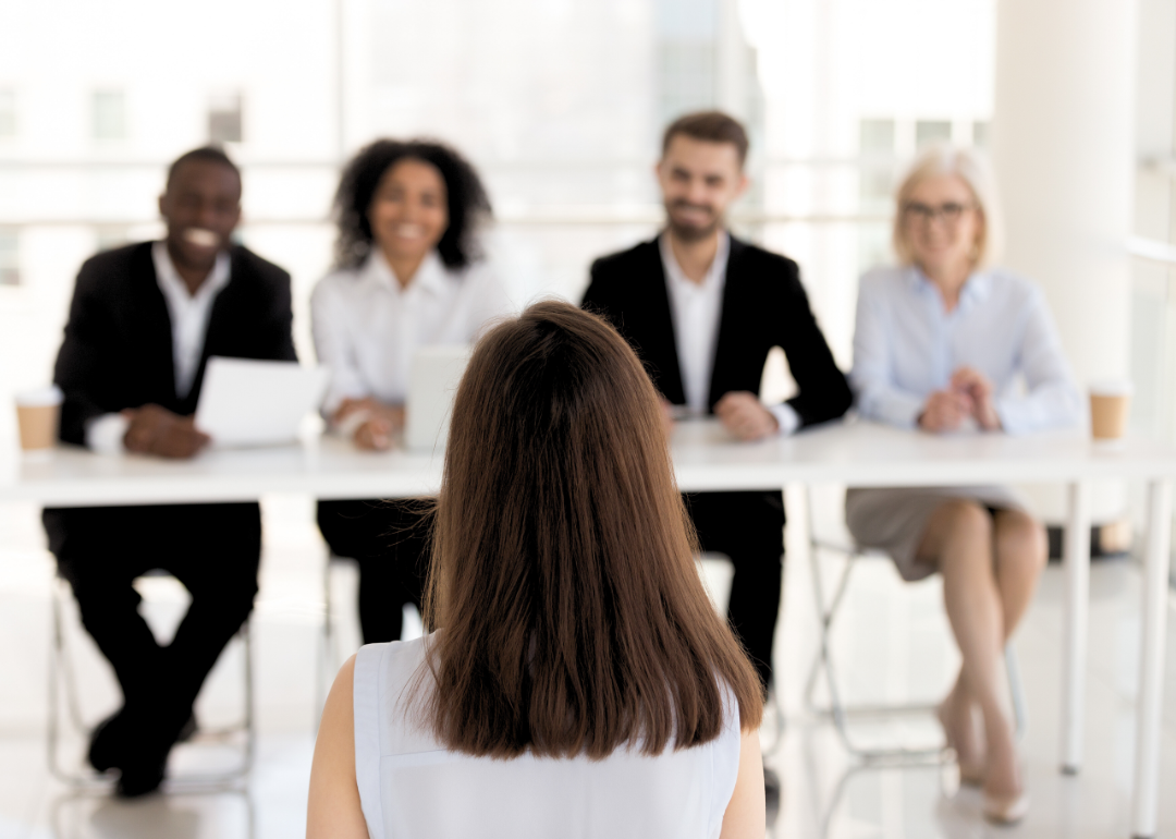 An applicant is interviewed by a board of four HR professionals.