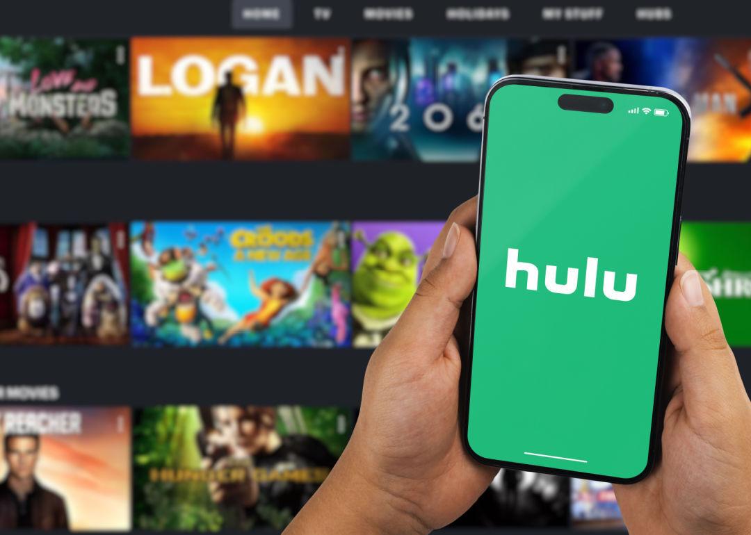 A person holding a phone with the Hulu app open.