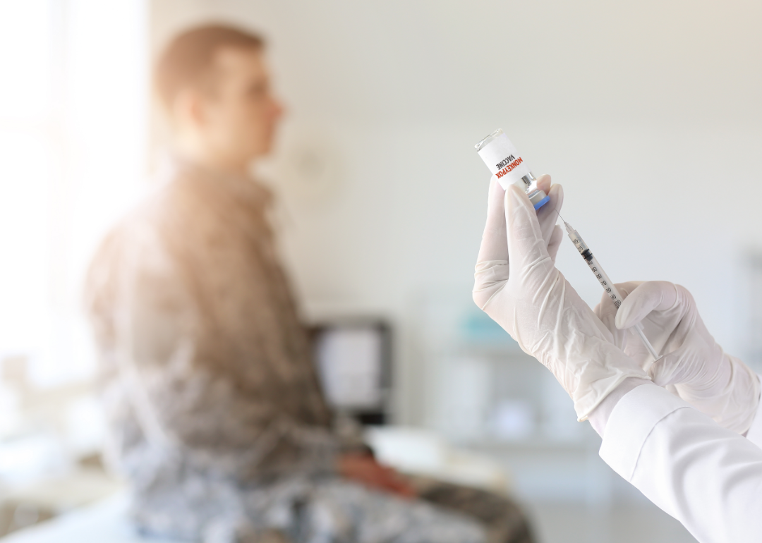 A patient awaits a vaccination by a doctor