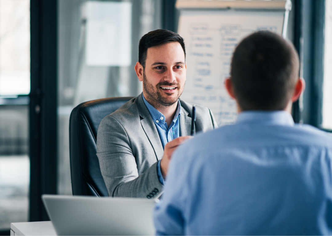 Two men in an office setting discuss their work