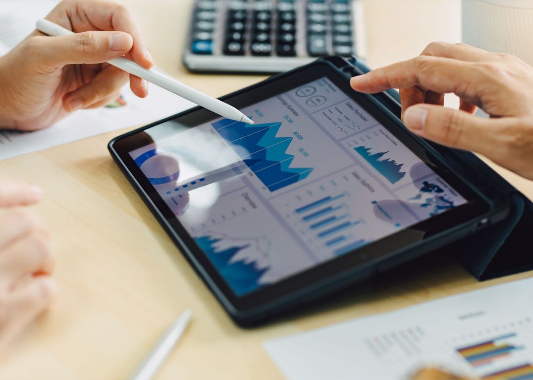 Two business colleagues analyzing company finances on a tablet.