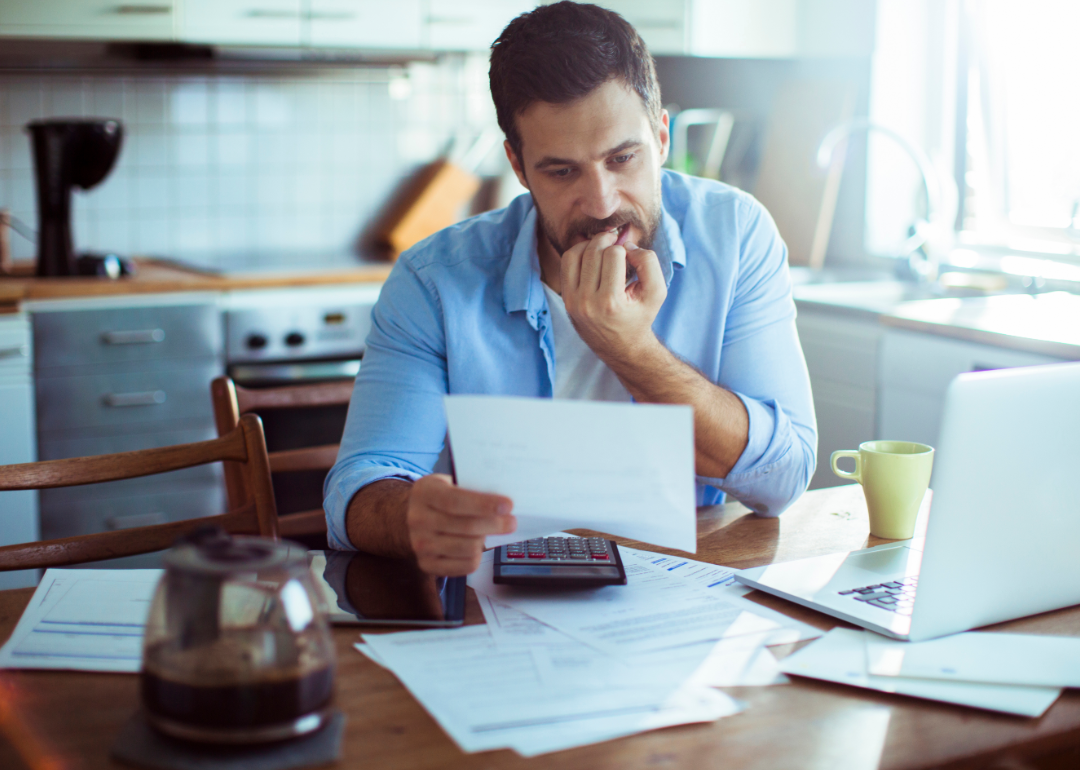 A man sitting at his kitchen table paying bills