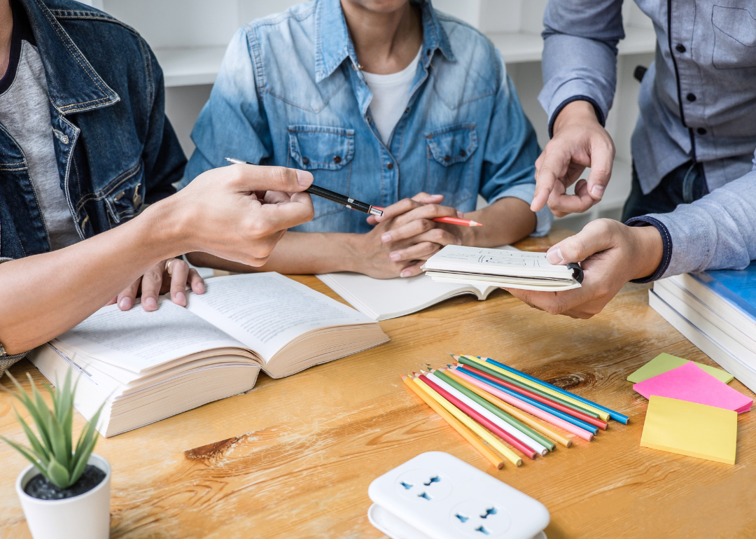 A tutor working with two students.