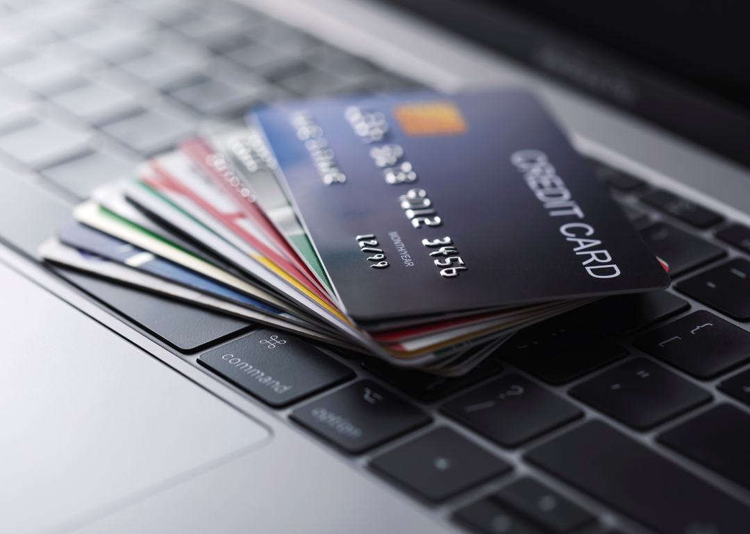 A stack of credit cards on a laptop.