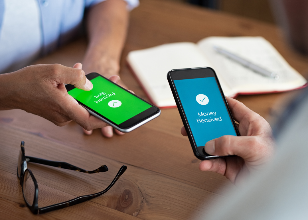 Two people using their mobile phones to send and receive money.