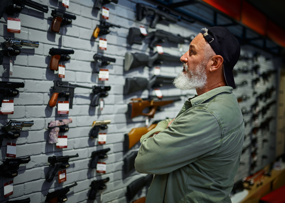 A customer choosing a pistol from the showcase in a gun store.