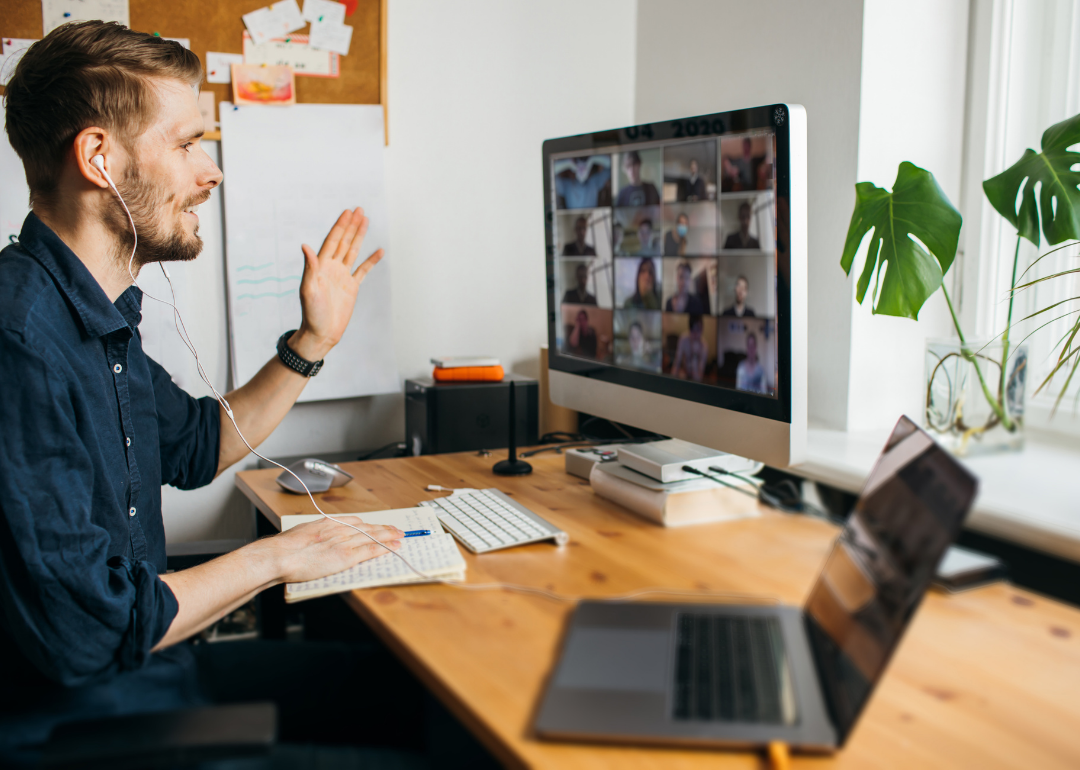 A young man having an onboarding video call in his home office