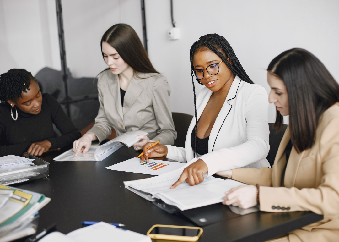 Four employees in professional attire having a business meeting.