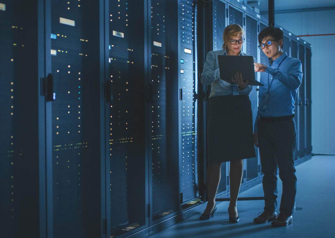 An engineer and an IT specialist doing a cybersecurity check in a modern data center.