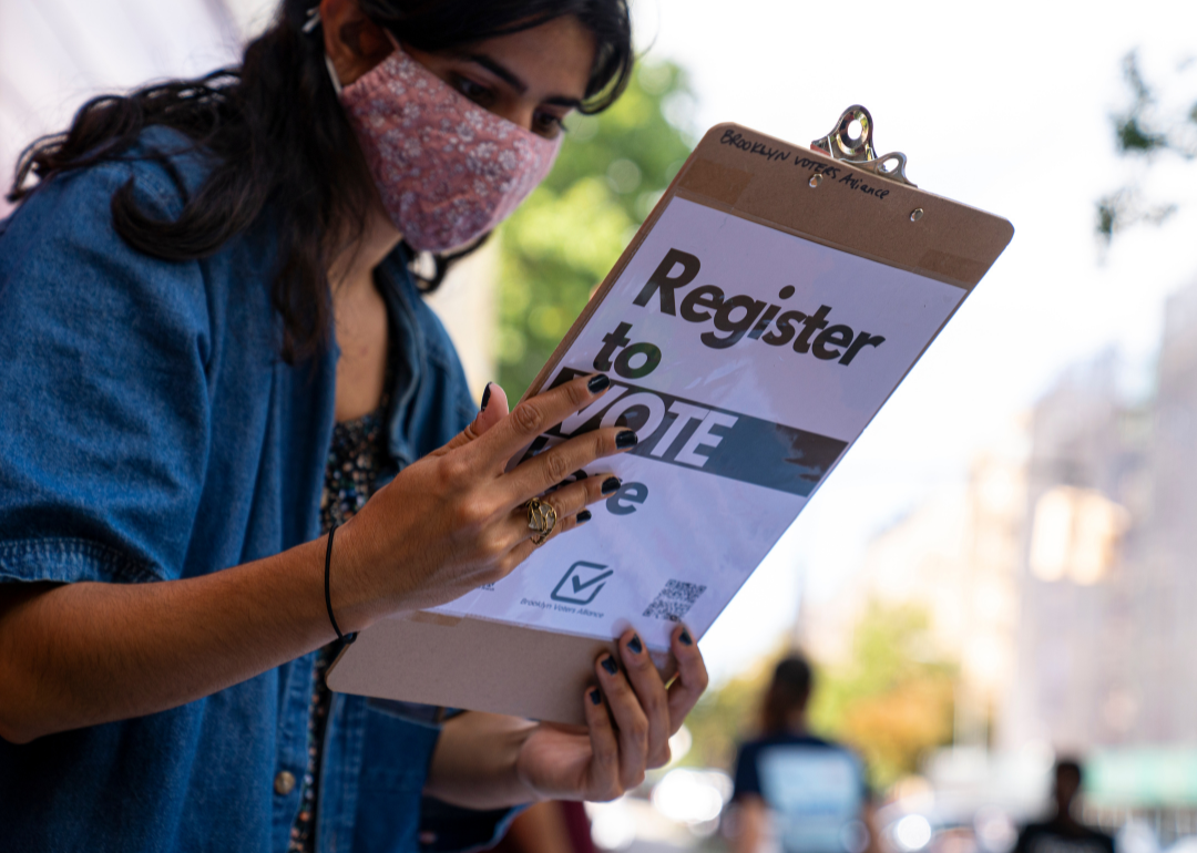 A volunteer from Brooklyn Voters Alliance checking a woman's application after she registered to vote