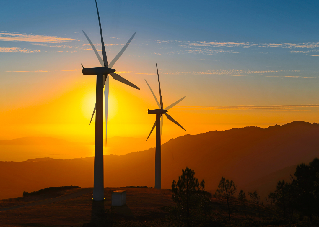 Two wind turbines at sunset