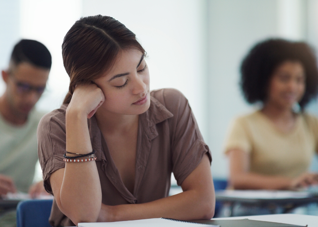 A woman falling asleep in a class.